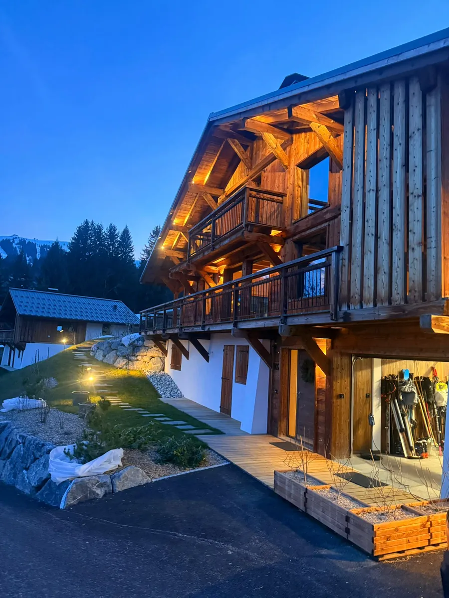 Façade de chalet éclairée au crépuscule