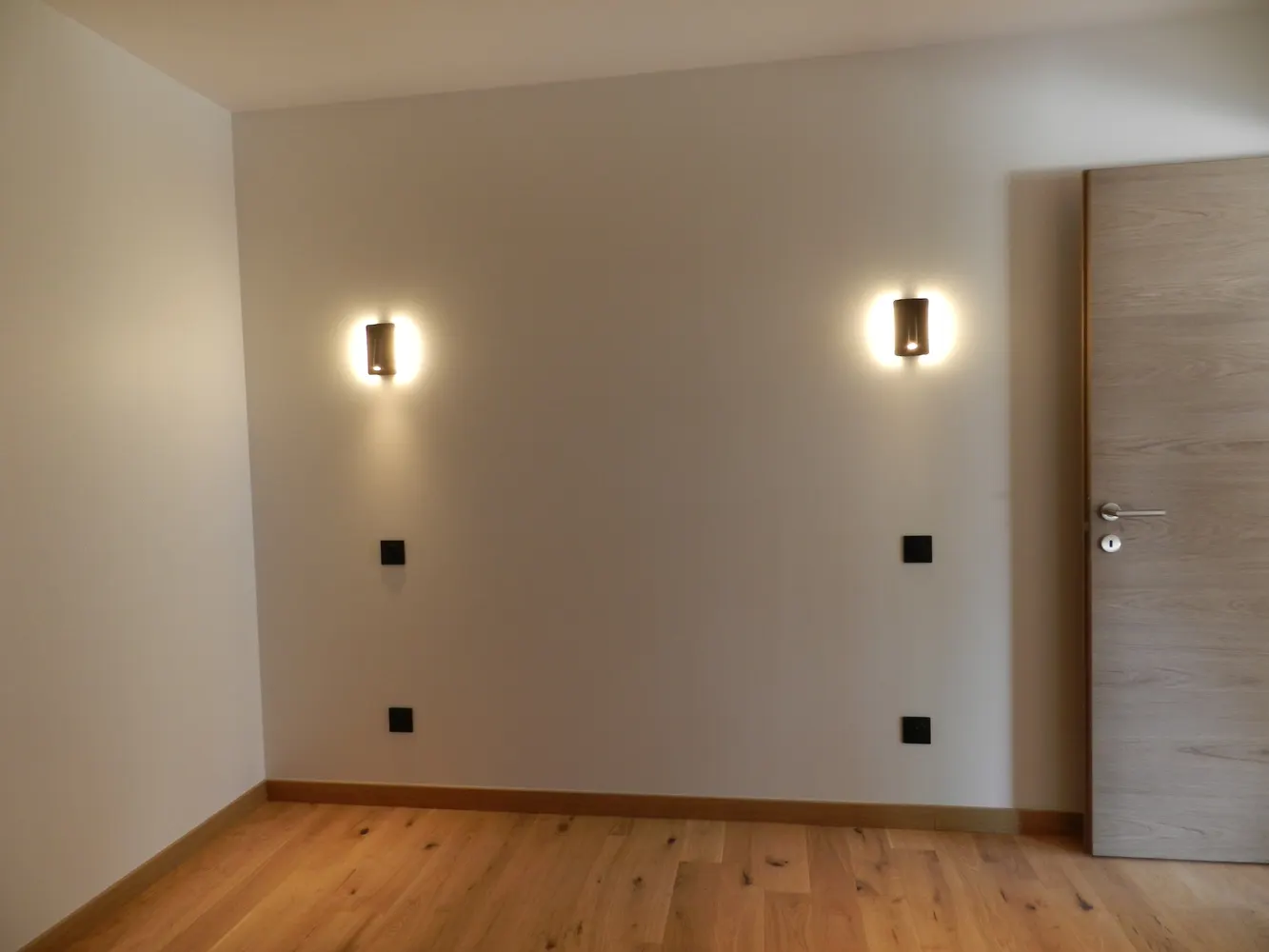 Chambre d'un appartement neuf avec appliques murales