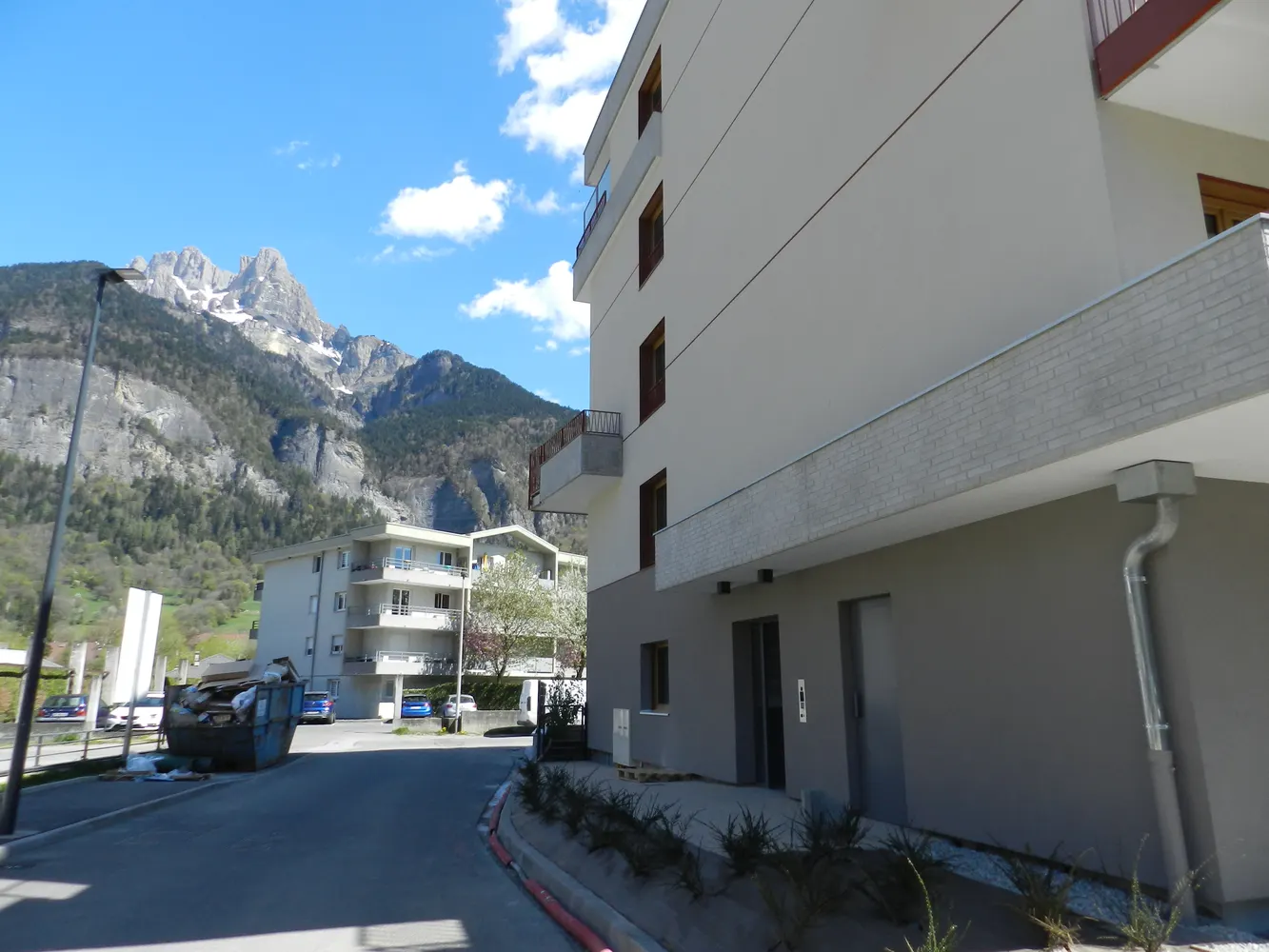 Façade d'un immeuble de logements neufs devant la montagne