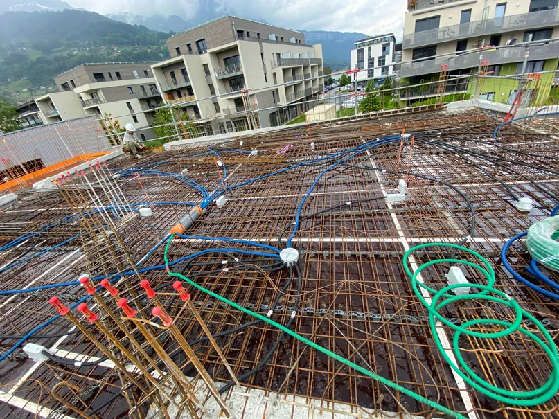 Gaines et pieuvres électriques posées sur une dalle avant le coulage du béton