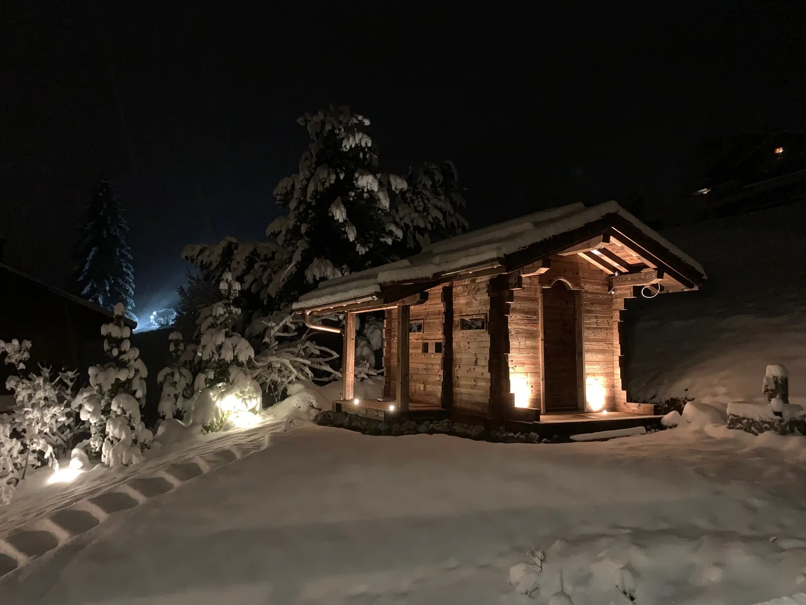 Mazot éclairé de nuit sous la neige en Haute-Savoie
