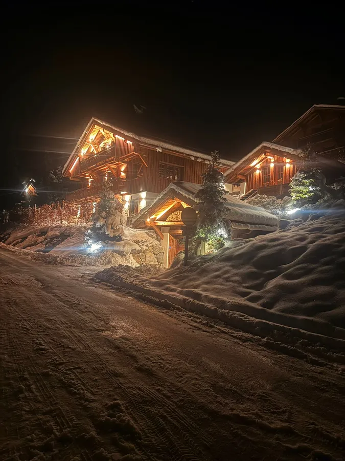Chalets éclairés de nuit sous la neige