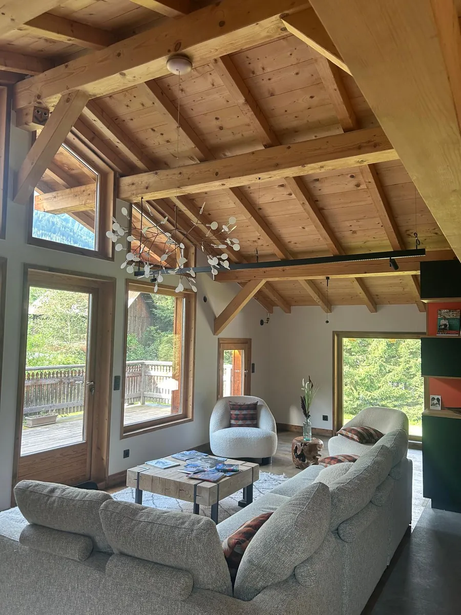 Séjour de chalet sous charpente avec éclairage